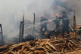 Lực lượng cứu hỏa đang dập tắt đám cháy. (Ảnh: Văn Trí/TTXVN)