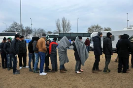 Dòng người di cư và tị nạn nhận lương thực, thực phẩm trong khi chờ đợi được qua cửa khẩu Hy Lạp-Macedonia, gần Idomeni (Hy Lạp) ngày 20/1. (Nguồn: AFP/TTXVN)