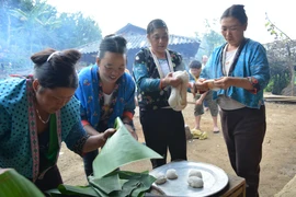 Phụ nữ dân tộc Mông tại xã Pá Lông, huyện Thuận Châu, Sơn La gói bánh dày. (Ảnh: Công Luật/TTXVN)