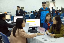 Nhân viên Cục Thuế Hà Nội hướng dẫn người nộp thuế nộp quyết toán thuế. (Ảnh: Hoàng Hùng/TTXVN)
