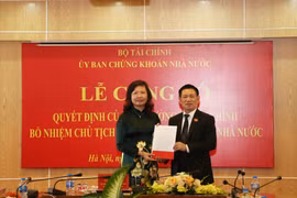 Bộ trưởng Bộ Tài chính Hồ Đức Phớc trao quyết định bổ nhiệm Chủ tịch Ủy ban Chứng khoán Nhà nước đối với bà Vũ Thị Chân Phương. (Ảnh: Vietnam+)