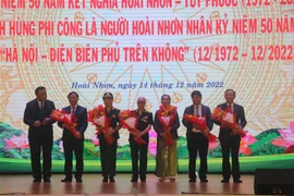 Tặng hoa cho người thân của 4 phi công Anh hùng lực lượng vũ trang nhân dân. (Ảnh: Sỹ Thắng/TTXVN)