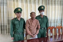 Đối tượng Nguyễn Văn Phán (giữa) bị bắt giữ trong trường hợp khẩn cấp. (Ảnh: TTXVN phát)