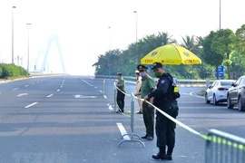 Lực lượng chức năng lập rào chắn triển khai chốt từ đường Võ Chí Công lên cầu Nhật Tân. (Ảnh: Hoàng Hiếu/TTXVN)