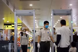 Nhân viên an ninh hàng không kiểm soát hành khách tại khu vực soi chiếu. (Ảnh: Huy Hùng/TTXVN)