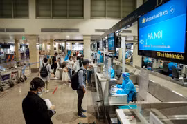 Hành khách Vietnam Airlines làm thủ tục ở quầy check-in sân bay Tân Sơn Nhất. (Ảnh: CTV/Vietnam+)