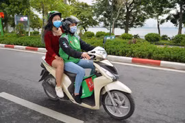 Nhu cầu di chuyển và đặt thức ăn trực tuyến gia tăng, nghề xe ôm công nghệ cũng có thêm đất sống. (Ảnh: CTV/Vietnam+)