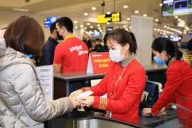 Hành khách làm thủ tục lên chuyến bay của hãng hàng không Vietjet. (Ảnh: CTV/Vietnam+)