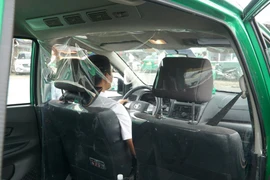 Xe taxi Mai Linh được lắp vách ngăn nhựa trong suốt để vận chuyển người dân đến Bệnh viện. (Ảnh: CTV/Vietnam+)