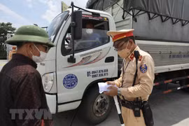 Phương tiện chở hàng thiết yếu sẽ được kiểm tra các điều kiện đảm bảo an toàn phòng, chống dịch COVID-19 khi qua chốt. (Ảnh: Minh Quyết/TTXVN)