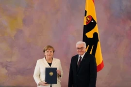 Bà Angela Merkel (trái) nhận quyết định bổ nhiệm từ Tổng thống Đức Frank-Walter Steinmeier sau khi tái đắc cử Thủ tướng Đức, tại Berlin ngày 14/3. (Nguồn: AFP/ TTXVN)