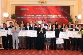 Thủ tướng Nguyễn Xuân Phúc trao tặng tiền số tiền cho 20 huyện nghèo qua đấu giá trái bóng và áo Đội tuyển U23 Việt Nam. (Ảnh: Thống Nhất/TTXVN)