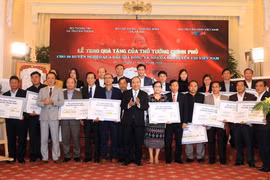 Thủ tướng Nguyễn Xuân Phúc trao tặng tiền số tiền cho 20 huyện nghèo qua đấu giá trái bóng và áo Đội tuyển U23 Việt Nam. (Ảnh: Thống Nhất/TTXVN)