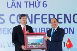 Thủ tướng Nguyễn Xuân Phúc tặng Chủ tịch Ngân hàng Phát triển châu Á (ADB) Takehiko Nakao bức ảnh do phóng viên TTXVN chụp các Trưởng đoàn tham dự Hội nghị Thượng đỉnh GMS 6. Ảnh: TTXVN