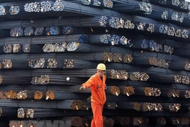 Công nhân vận chuyển thép cuộn tại một chợ thép ở Qingdao, tỉnh Sơn Đông, Trung Quốc. (Nguồn: AFP/TTXVN)