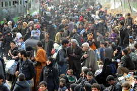 Người dân sơ tán khỏi thị trấn Hamouriyeh, Đông Ghouta, Syria ngày 15/3. (Nguồn: THX/TTXVN)