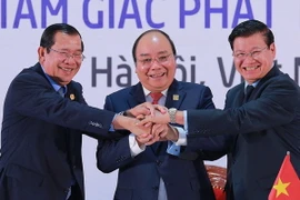 Ba thủ tướng thể hiện tinh thần đoàn kết và hợp tác 3 nước sau khi ký kết Tuyên bố chung Hội nghị Cấp cao hợp tác Khu vực Tam giác phát triển Campuchia-Lào-Việt Nam (CLV) lần thứ 10. (Ảnh: TTXVN)