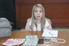 Đối tượng Lê Thị Thắm và tang vật. (Ảnh: Văn Đức/TTXVN)