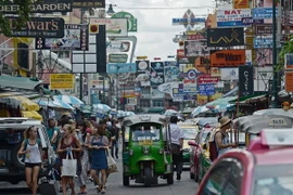 Khách du lịch dạo chơi trên một tuyến phố thương mại ở thủ đô Bangkok. (Nguồn: AFP/TTXVN)
