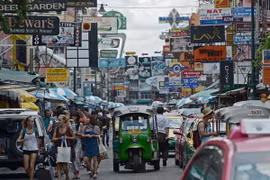 Khách du lịch dạo chơi trên một tuyến phố thương mại ở thủ đô Bangkok. (Nguồn: AFP/TTXVN)