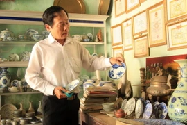 Thầy giáo Võ Thanh Phương với những cổ vật sưu tầm được. (Ảnh: Phước Ngọc/TTXVN)