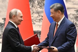 Tổng thống Nga Vladimir Putin (trái) và Chủ tịch Trung Quốc Tập Cận Bình trao đổi văn kiện tại Lễ ký Tuyên bố chung ở Bắc Kinh, ngày 16/5/2024. (Ảnh: AFP/TTXVN)