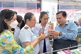 Đoàn giám sát Hội đồng Nhân dân Thành phố Hồ Chí Minh kiểm tra tại một cơ sở kinh doanh thuốc trên địa bàn quận Tân Phú. (Ảnh: Đinh Hằng/TTXVN)
