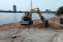 Dọn đống đất đá, xà bần ven bờ Sông Hàn. (Ảnh: Quốc Dũng/TTXVN)