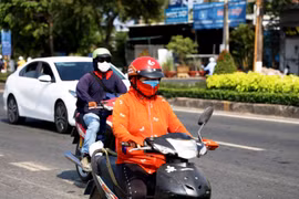 Người dân Bến Tre bịt kín tránh nắng nóng. (Ảnh: Hồng Đạt/TTXVN)