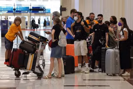 Hành khách tại Sân bay Quốc tế Dubai (UAE). (Ảnh: AFP/TTXVN)
