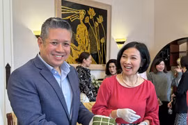 Hội viên ASC của Đại sứ quán Singapore tại Mỹ với sản phẩm bánh chưng do mình gói. (Ảnh: Kiều Trang/TTXVN)