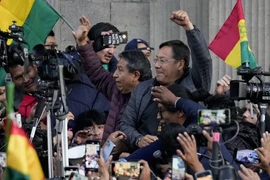 Tổng thống Bolivia Luis Arce giơ nắm đấm siết chặt giữa những người ủng hộ và giới truyền thông, bên ngoài dinh thự của chính phủ ở La Paz (Bolivia), ngày 26/6/2024. (Nguồn: AP)
