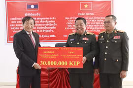 Đại sứ Nguyễn Bá Hùng thay mặt Đại sứ quán Việt Nam tại Lào tặng quà cho Ban Giám hiệu Trường Văn hóa Dân tộc Nội trú Quân đội Nhân dân Lào. (Ảnh: Đỗ Bá Thành/TTXVN)