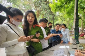 Cán bộ công an hướng dẫn người dân thực hiện cấp Phiếu Lý lịch tư pháp trên VNeID. (Ảnh: Kim Anh/TTXVN)