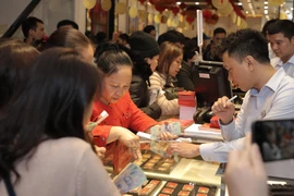 Khách hàng đang giao dịch vàng miếng. (Ảnh: Đức Duy/Vietnam+)