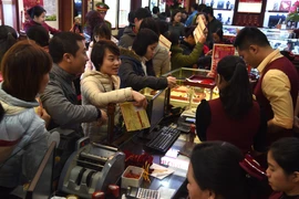 Khách hàng đang giao dịch vàng miếng. (Ảnh: Đức Duy/Vietnam+)