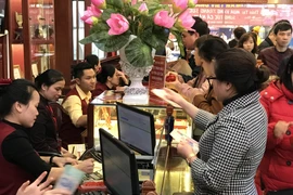 Khách hàng đang giao dịch vàng miếng. (Ảnh: Đức Duy/Vietnam+)