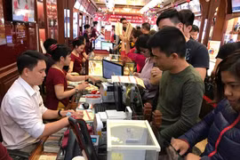 Khách hàng giao dịch vàng miếng tại Bảo Tín Minh Châu. (Ảnh: Đức Duy/Vietnam+)