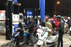 Nhân viên Petrolimex đang bán xăng cho khách hàng. (Ảnh: Đức Duy/Vietnam+)