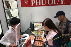 Khách hàng đang giao dịch vàng miếng. (Ảnh: Đức Duy/Vietnam+)