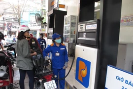 Nhân viên Petrolimex đang bán xăng cho khách hàng. (Ảnh: Đức Duy/Vietnam+)