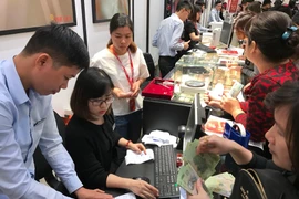 Khách hàng đang giao dịch vàng miếng. (Ảnh: Đức Duy/Vietnam+)