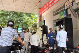 Nhân viên Petrolimex đang bán xăng cho khách hàng. (Ảnh: Đức Duy/Vietnam+)