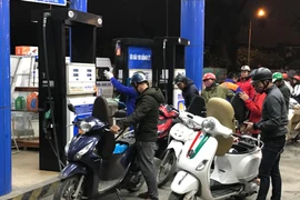 Nhân viên Petrolimex đang bán xăng cho khách hàng. (Ảnh: Đức Duy/Vietnam+)
