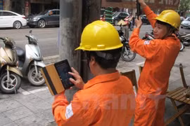 Nhân viên ngành điện đang chốt chỉ số côngtơ của khách hàng. (Ảnh: Đức Duy/Vietnam+)