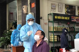 Lực lượng chức năng tỉnh Gia Lai tiến hành lấy mẫu xét nghiệm có liên quan đến các trường hợp dương tính với SARS-CoV-2. (Ảnh: Quang Thái/TTXVN)