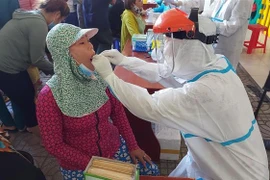 Các cán bộ y tế tiến hành lấy mẫu xét nghiệm COVID cho người dân xã Phước Tỉnh, huyện Long Điền, tỉnh Bà Rịa-Vũng Tàu vào chiều ngày 30/6. (Ảnh: Hoàng Nhị/TTXVN)