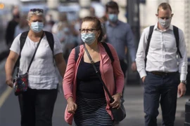 Người dân đeo khẩu trang phòng dịch COVID-19 khi đi trên đường phố ở London, Anh ngày 19/7/2021. (Ảnh: THX/TTXVN)