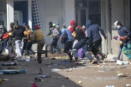 Các đối tượng cướp phá tại một cửa hàng ở Johannesburg, Nam Phi ngày 12/7/2021. (Ảnh: AFP/TTXVN)