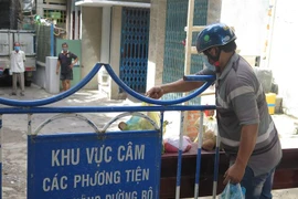 Người dân tiếp tế lương thực, thực phẩm cho người dân ở trong khu phong tỏa tổ dân phố 7 Hà Ra, phường Vĩnh Phước, thành phố Nha Trang, tỉnh Khánh Hòa. (Ảnh: Phan Sáu/TTXVN)